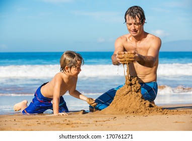 Father and son playing together in the sand on tropical beach, Building sand castle - Powered by Shutterstock