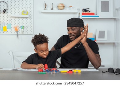 father and son practicing their learning skills science toy. With electronic electrical connection simulation robot, brain development and learning experiment circuit board. to become future inventors - Powered by Shutterstock