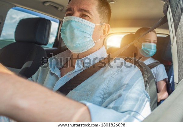 Father and son in protective masks  driving car,\
Happy traveler family. Bonding Travel, Summer, Holidays, Journey,\
Trip concept.