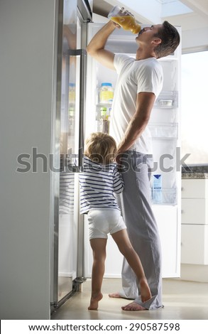 Father And Son Raiding The Fridge For Drink