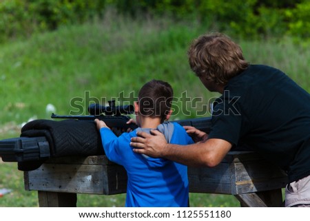 Father and son at the range practicing target shooting