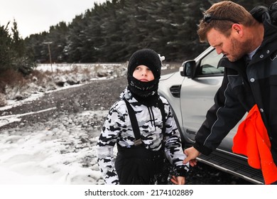 Father And Son Removing Snow Gear At Vehicle After Fun In The Snow