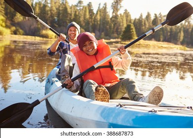 Father And Son Rowing Kayak On Lake - Powered by Shutterstock