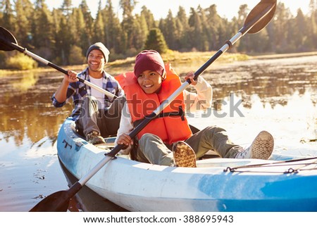 Father And Son Rowing Kayak On Lake