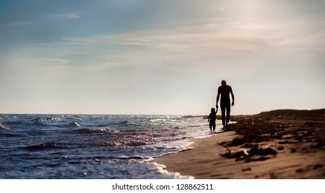 father and son to the sea at sunset