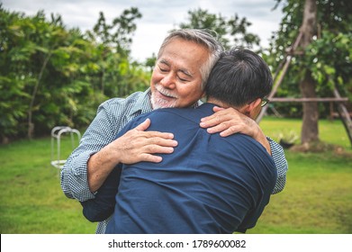 Father and son show love by hugging in outdoors, asian family