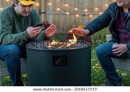 Father and son sitting around a backyard fire