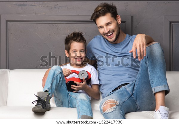 Father and son are\
sitting on the couch