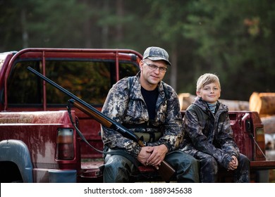 Father And Son Sitting Together In Truck Outdoors With Shotgun Hunting Gear.