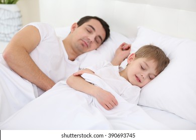 Father and son sleeping in bed at home - Powered by Shutterstock