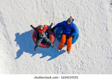 Father And Son Snow Tubing In The Winter In Canada