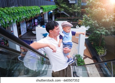 Father And Son Spending Time Shopping, Cute Little Asian 1 Year Old Toddler Baby Boy Child And Dad Standing On Moving Escalator At The Open Air Department Store / Community Mall, Protection Concept