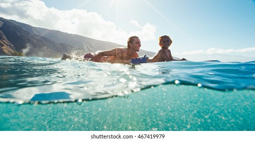 Father and son surfing together, summer lifestyle fun - Powered by Shutterstock