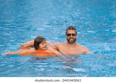 Father and son swimming in pool, summer family weekeng. Little kid boy with father splashing in swimming pool. Family leisure and summer vacation. Kid with dad having fun on beach. Happy kids on sea. - Powered by Shutterstock