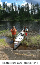 Father And Son Taking A Break From Canoeing In The Boundary Waters Canoe Area Wilderness. MINNESOTA, JUNE 22, 2012