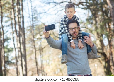 Father And Son Taking Photo In Park