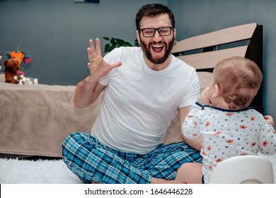 Father And Son. The Father Teaches The Child To Walk On The Potty. Father Is Very Happy. Dad Is Very Happy About The Success Of His Son. Baby Toiletries. Potty Training