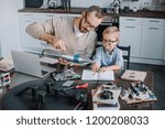 father and son testing rocket model together at home