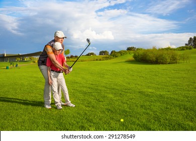 Father with son are training at golf course 