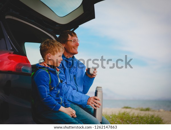 father and son\
travel by car at winter\
beach