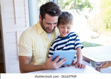 Father and son using tablet pc in the living room at home