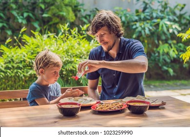 Father and son using wash hand sanitizer gel before eating in a cafe. - Powered by Shutterstock