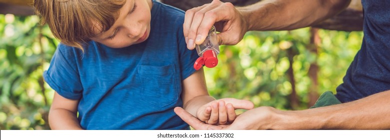 Father And Son Using Wash Hand Sanitizer Gel In The Park Before A Snack. BANNER, Long Format