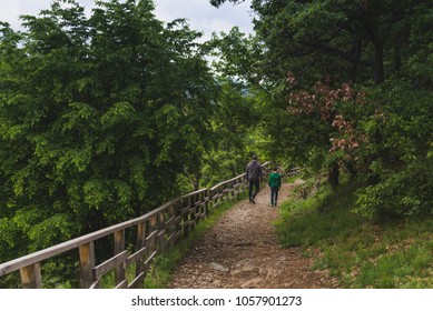 Father and son walking down a mountain path. Concept of friendship, affection and spending time together.