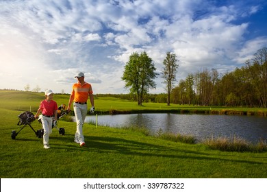 Father with son are walking at golf field
