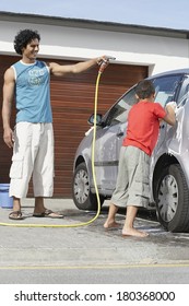 Father And Son Washing The Car Near Home Garage