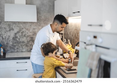 Father and son washing dishes in the kitchen at home
 - Powered by Shutterstock