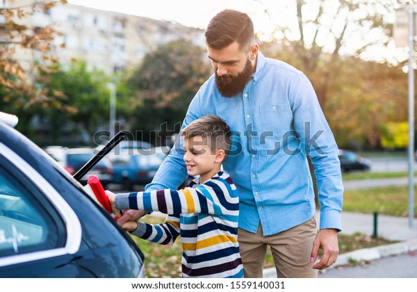 Father and son\
washing their car\
together.