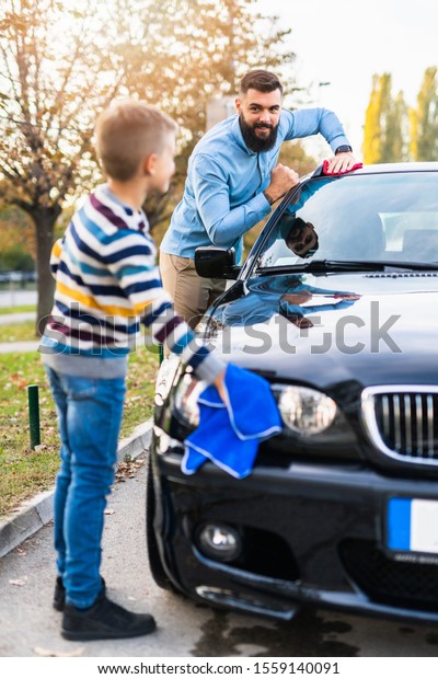 Father and son\
washing their car\
together.