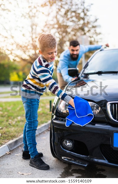 Father and son
washing their car
together.