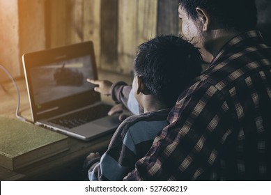 Father And Son Watching Action Movie Excited On Laptop.