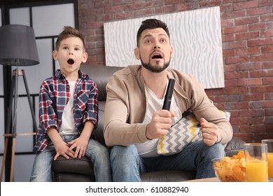 Father and son watching sports on TV at home - Powered by Shutterstock