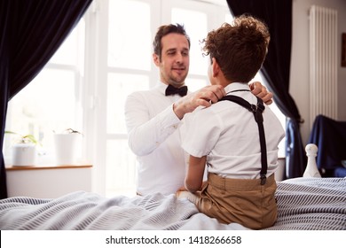 Father And Son Wearing Matching Outfits Getting Ready For Wedding At Home