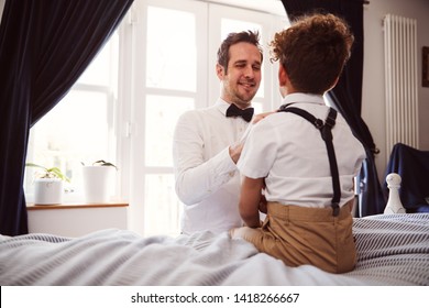 Father And Son Wearing Matching Outfits Getting Ready For Wedding At Home