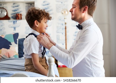 Father And Son Wearing Matching Outfits Getting Ready For Wedding At Home