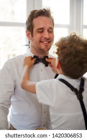 Father And Son Wearing Matching Outfits Getting Ready For Wedding At Home