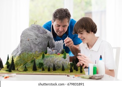 Father And Son Work On Model Building School Project. Kids And Parent Build Miniature Scale Model Mountain For Geography Class. Extracurricular Activities And Family Hobby. Art And Crafts For Child.