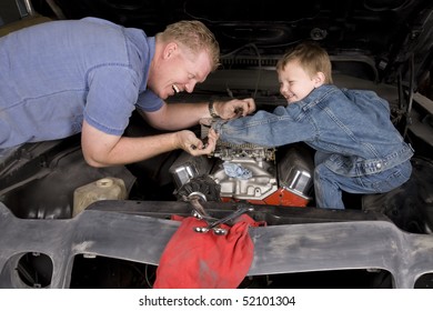 A father and son working together restoring an engine, with happy expressions on their faces.