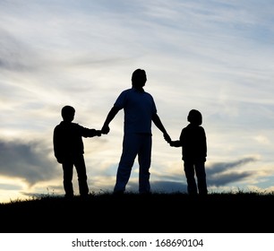 Father with sons playing on sunset meadow