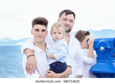 Father And Sons At Sea. Family On Viewing Platform Near The Coin Operated Binoculars. Tourism And Family Concept. Spain. Costa Brava. 