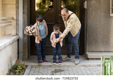 Father And Sons Splashing Water For A Good Luck Before 1St Day At School