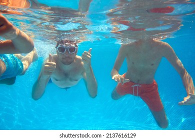 Father With Sons Underwater In Swimming Pool Giving Thumbs Up Gesture - Powered by Shutterstock