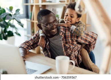 father spending time with son and working with laptop