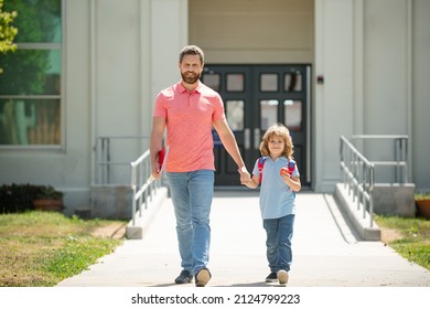 Father Supports And Motivates Son. Kid Going To Primary School. Parent With Child In Front Of School Gates. Father Walking To School With Child.
