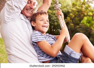 Father swinging with son at a playground - Powered by Shutterstock