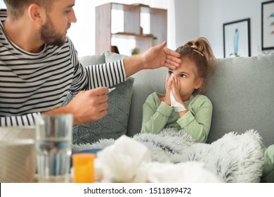 Father taking care of his daughter ill with flu at home - Shutterstock ID 1511899472